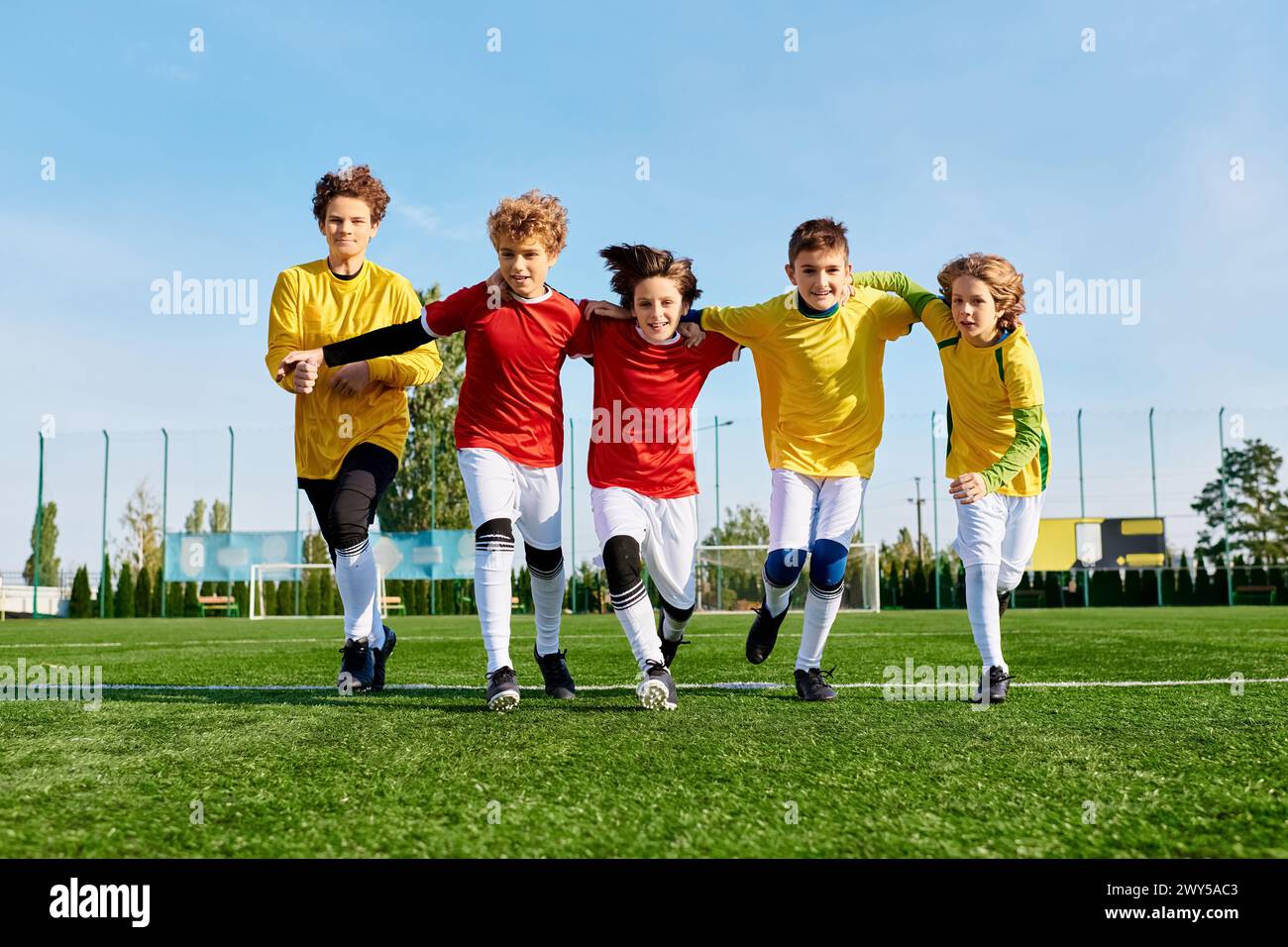 A group of young men engaged in a lively soccer game, kicking the ball around as they compete on the field with energy and teamwork. Stock Photo