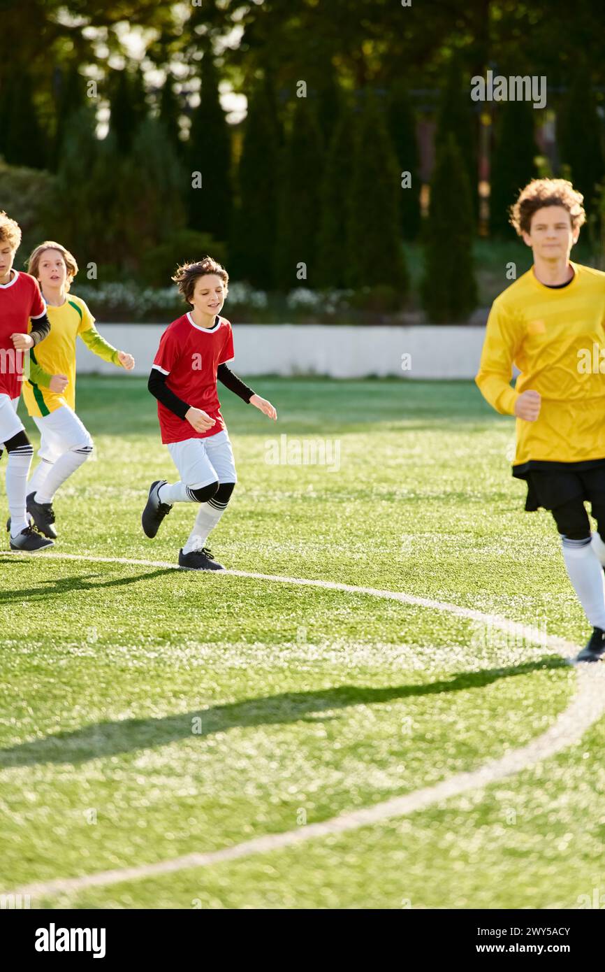 A group of energetic young boys in football jerseys passionately playing a game of soccer on a grassy field. They are running, kicking, passing, and s Stock Photo