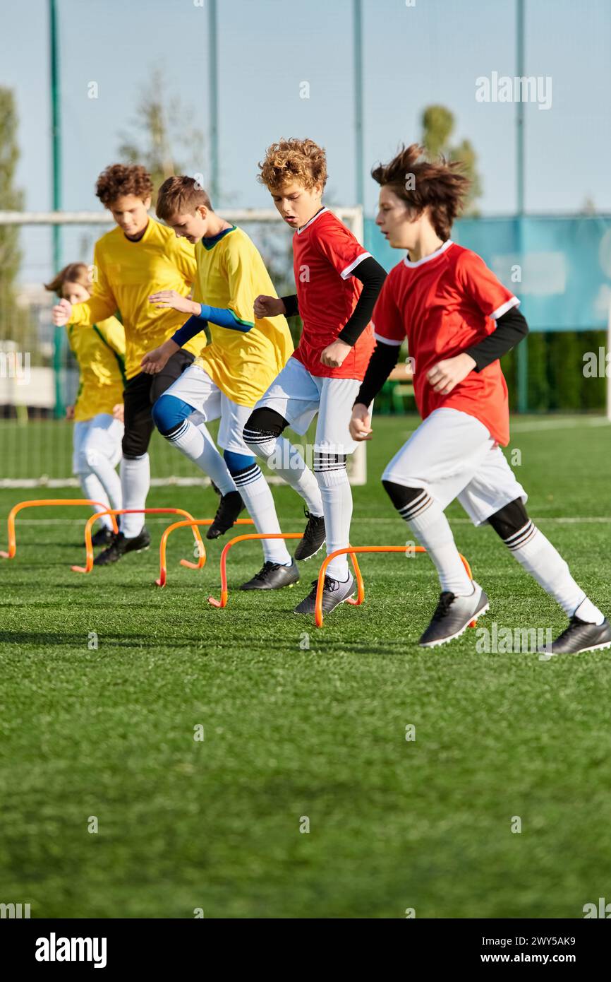 A group of young boys enthusiastically playing a game of soccer on a grassy field, running, kicking, and passing the ball with excitement and focus. Stock Photo