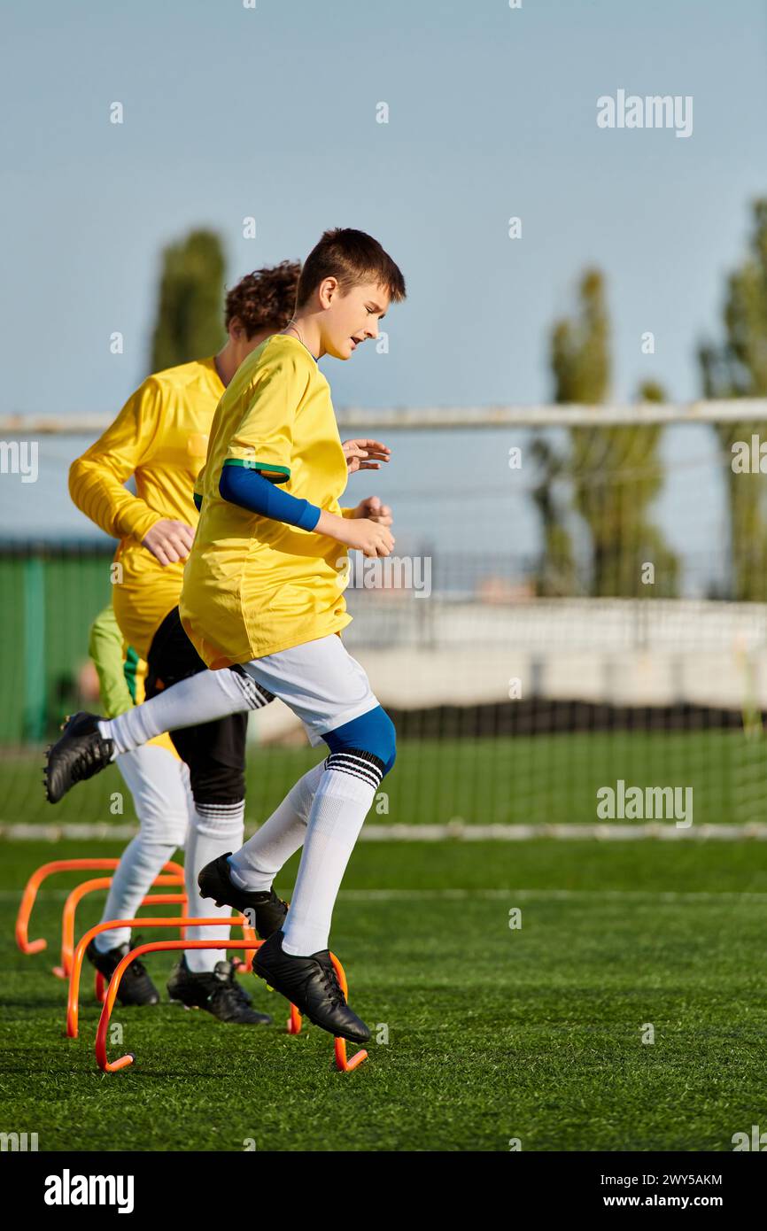 Two young girls are energetically playing soccer on a grassy field. They are both in motion, kicking the ball back and forth, with expressions of focu Stock Photo