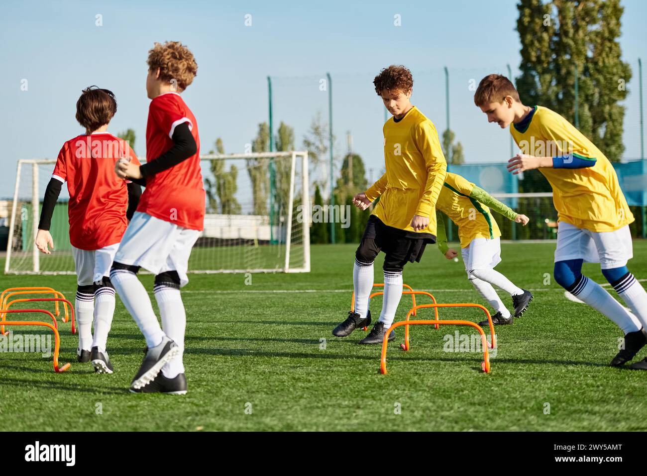 A dynamic scene of a group of young men engaged in an exhilarating game of soccer, running, passing, and kicking the ball with precision and skill on Stock Photo