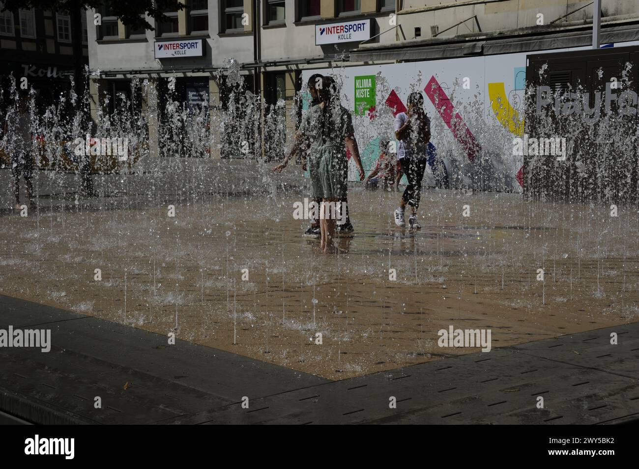 Kids are playing in a dynamic water fountain in Hameln, Germany Stock Photo