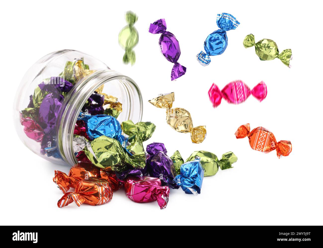 Candies in bright wrappers falling over jar on white background Stock Photo