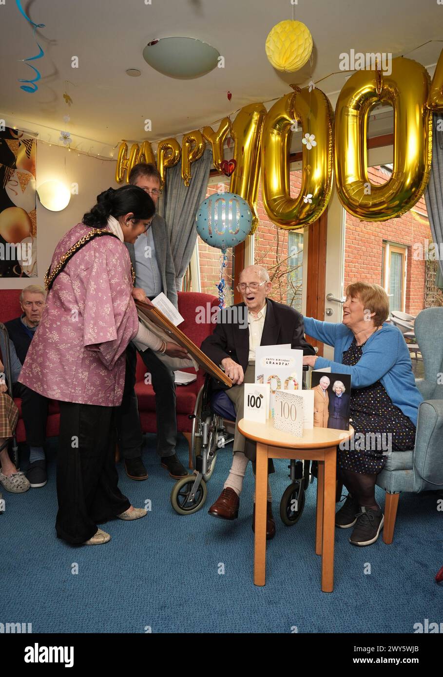 Ronald Brignall, receives his bravery award from the Lord Mayor of Cardiff, Councillor Bablin Molik, for saving Cardiff's City Hall from destruction during a German air raid in the Second World War as a 16-year-old, during a party to celebrate his 100th birthday at his care home in Steyning, West Sussex. Picture date: Thursday April 4, 2024. Stock Photo