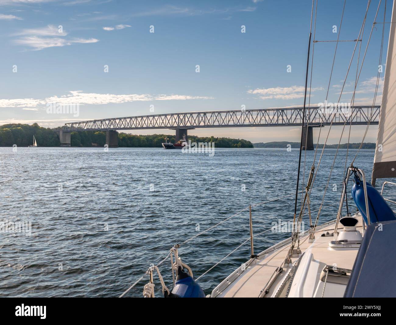 Sailboat sailing towards Old Little Belt Bridge connecting Jutland and Funen in Southern Denmark, Denmark Stock Photo