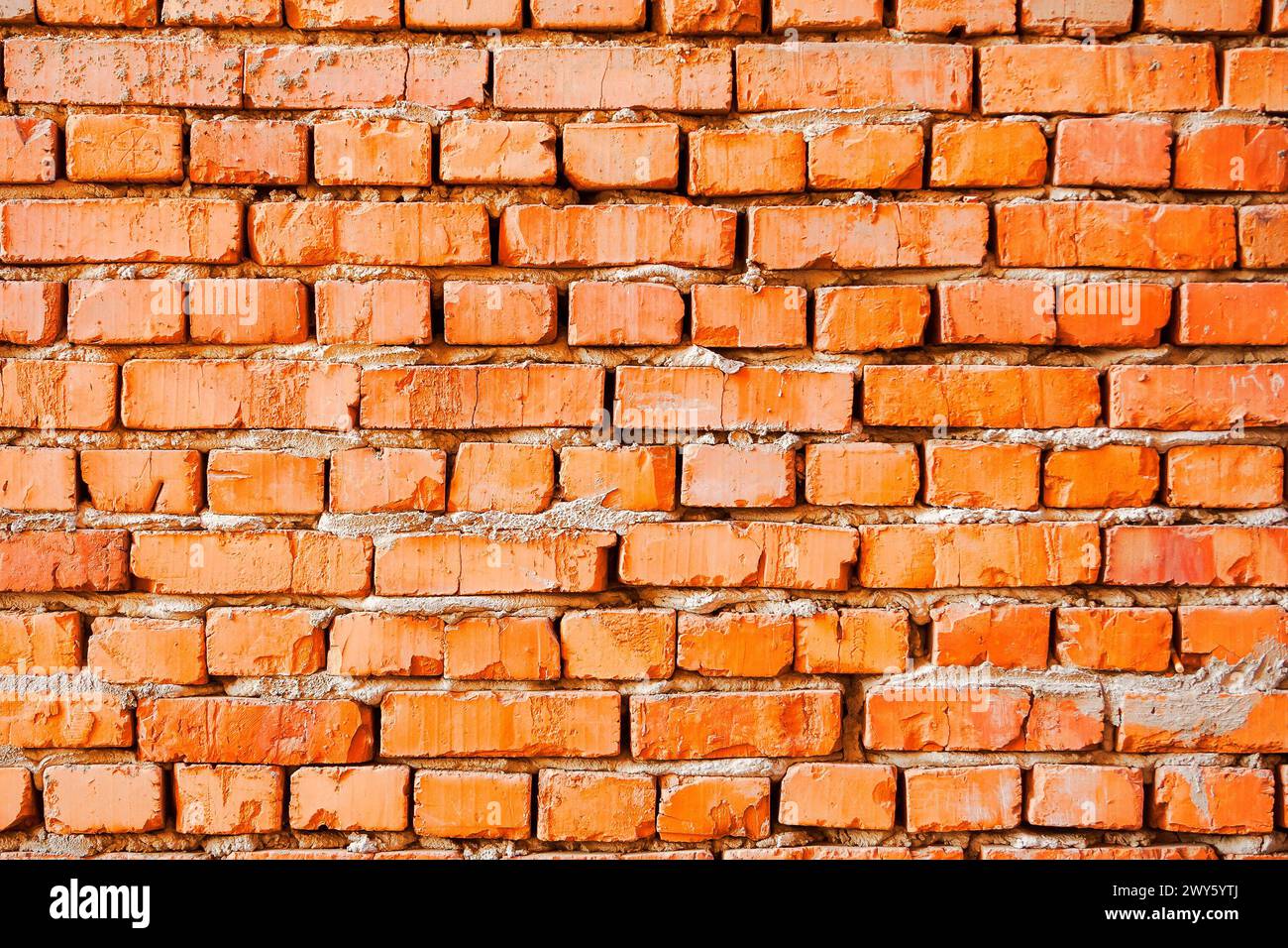 grungy pattern of an orange brick wall. not finished or abandoned architecture development concept. dirty and uneven texture Stock Photo