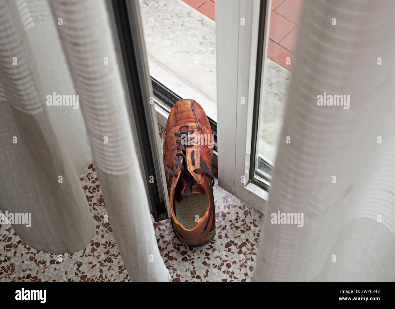 man's shoe holding door window open to let in fresh air Stock Photo