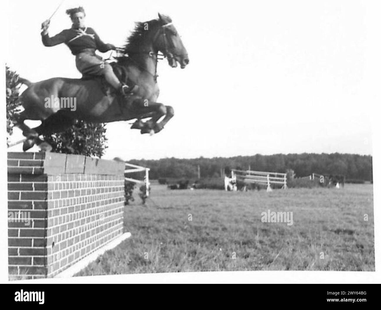 8TH ARMOURED BRIGADE HORSE SHOW - Corporal J.H.Body, 1st Bn. K.O.Y.L.I. takes the Wall Jump. , British Army of the Rhine Stock Photo