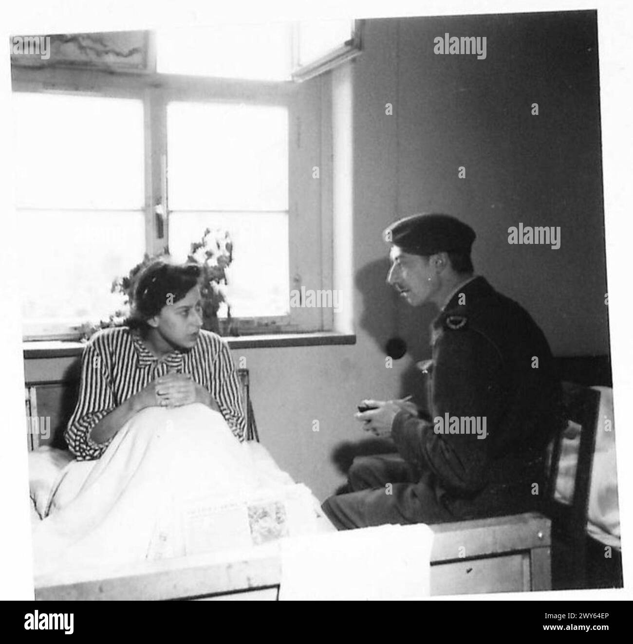 BELSEN CONCENTRATION CAMP - He then goes into the new makeshift but comparatively luxurious hospitals where he is seen talking to a beautiful young Hungarian girl of royal descent who had much to tell about the horrors of Belsen and the even more infamous Auschwitz concentration camp. , British Army, 21st Army Group Stock Photo