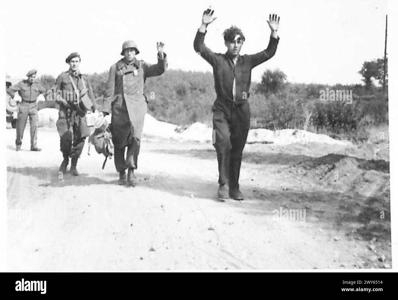 VARIOUS SCENES IN BELGIUM - A Belgian paratrooper with two prisoners. Both are Belgians serving in the German Army. The leading one was captured in a farmhouse where he was in hiding and had changed into civilians clothes. The one in uniform gave information as to the whereabouts of the other. , British Army, 21st Army Group Stock Photo