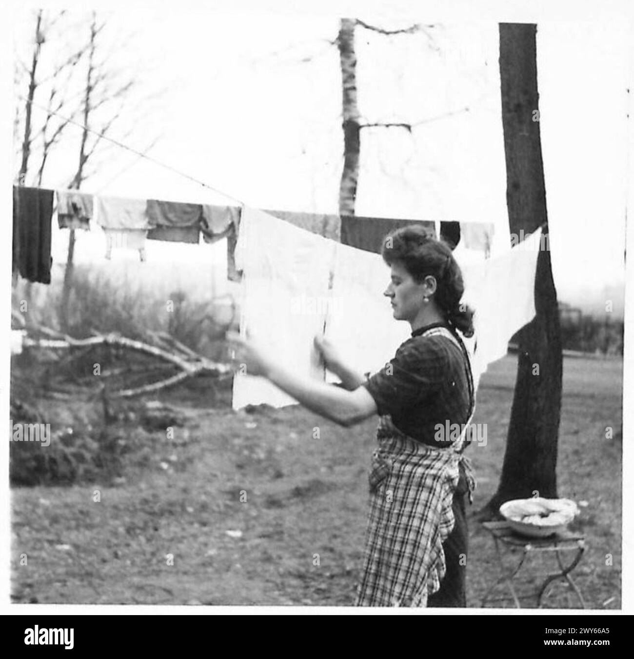 GERMAN CIVILIANS UNDER MILITARY GOVERNMENT - The housewife still carries on with her washing, now a little harder owing to the scarcity of soap. , British Army, 21st Army Group Stock Photo