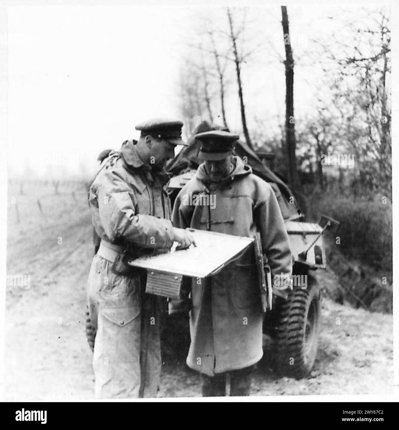 2ND ARMY ADVANCE INTO GERMANY! - Brigadier Wingfield, DSO., MC., Commander of the 22nd Armoured Bde., going over a map with Lieut. Colonel Knox, prior to the attack of Weseke. , British Army, 21st Army Group Stock Photo