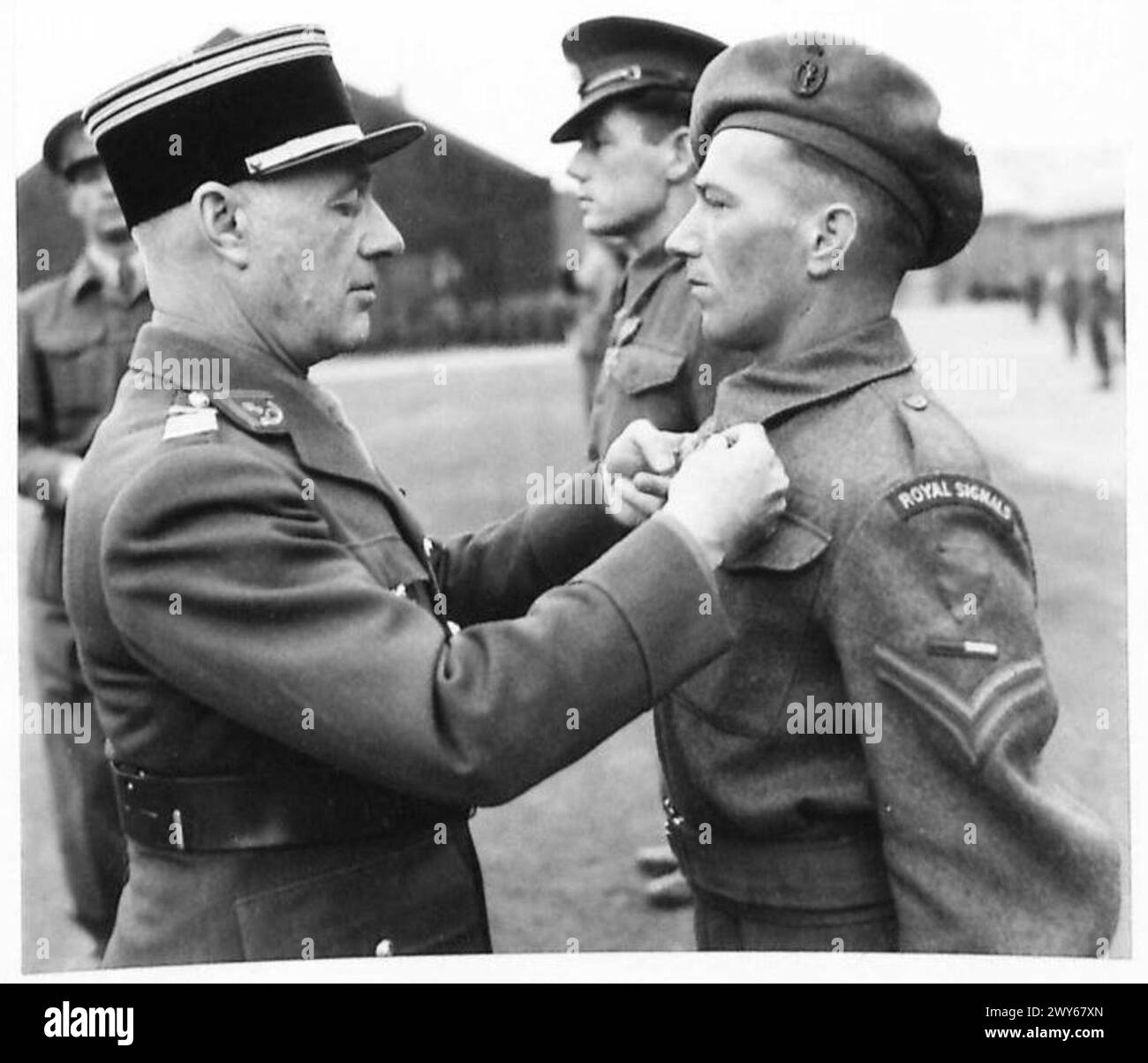 PRESENTATION OF CROIX PE GUERRE [613 REGT. R.A. , 37 R.H.U.] - Corporal A.A. Price 2317711 of 158 AAOR Sigs. receives the Croix de Guerre from Colonel HI Troullier. , British Army, 21st Army Group Stock Photo
