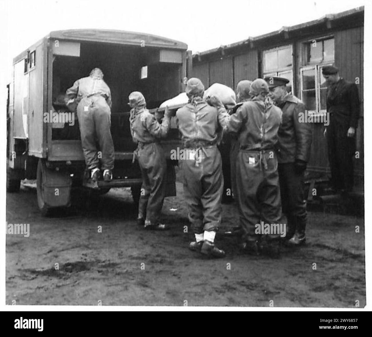 BELSEN CONCENTRATION CAMP - Men of the Light Field Ambulance evacuating men suffering from Typhus from their infested huts. These will be bathed, deloused and, in a fresh clean blanket, taken into our new makeshift hospital in the old ��S.S.' barracks which adjoins the camp. Those who are able to walk are escorted to the bath house, a temporary system we have erected in the old camp crematorium, where they each receive one piece of soap and a clean towel. After bathing, they are deloused and fitted with new clothes [collected locally from the German civilians]. Their old infested rags are then Stock Photo