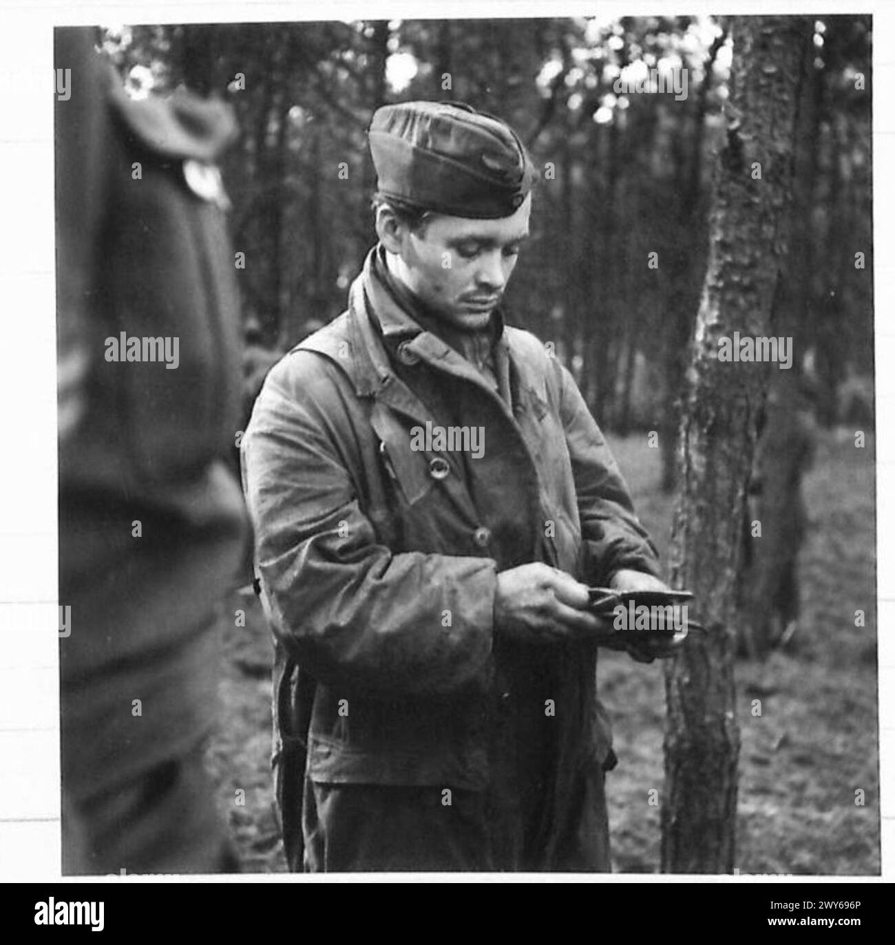 GERMAN PRISONERS. - A four-Feet Paratrooper hands over his Pay Book. , British Army, 21st Army Group Stock Photo