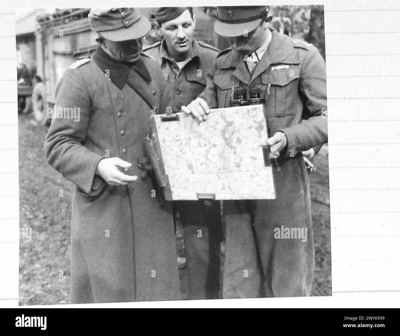 AMERICAN AIRMEN PRISONERS LIBERATED AT GUDOW TODAY - The German Commander points out some locations on the map to Frank Troy of Boston, and Lieutenant Turnbull of the Royal Dragoons. , British Army, 21st Army Group Stock Photo