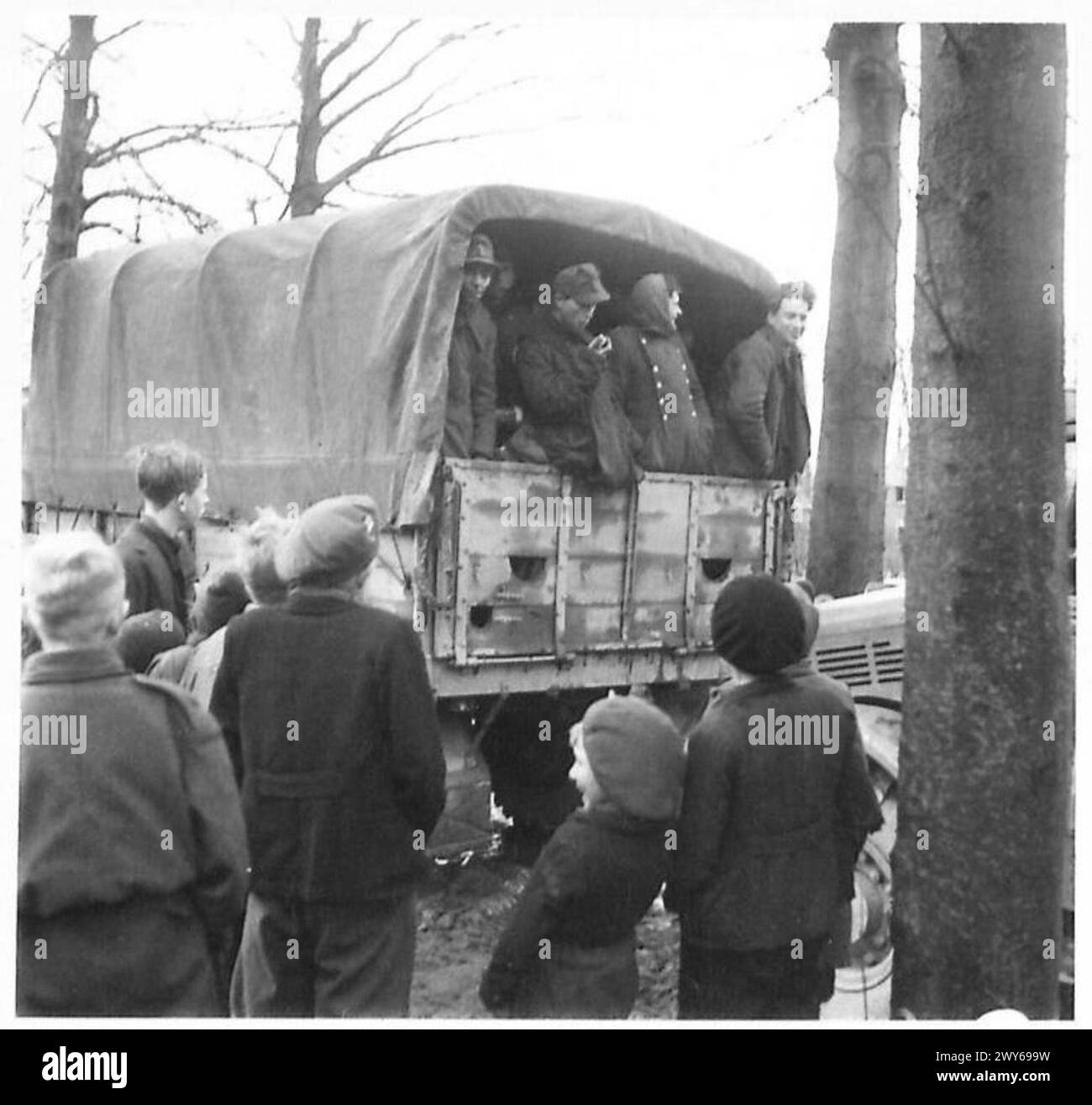 OPERATION VERITABLE CONTINUED THE ALLIED ATTACK THROUGH SIEGFRIED LINE - Some of the 450 German prisoners taken in the Reichwald sector by 53 Div. The picture shews them being marched in and transported to the back areas in Army lorries. They were watched by the Dutch civilians who showed their happiness and delight at the downfall of their recent oppressors. Children were particularly demonstrative. , British Army, 21st Army Group Stock Photo