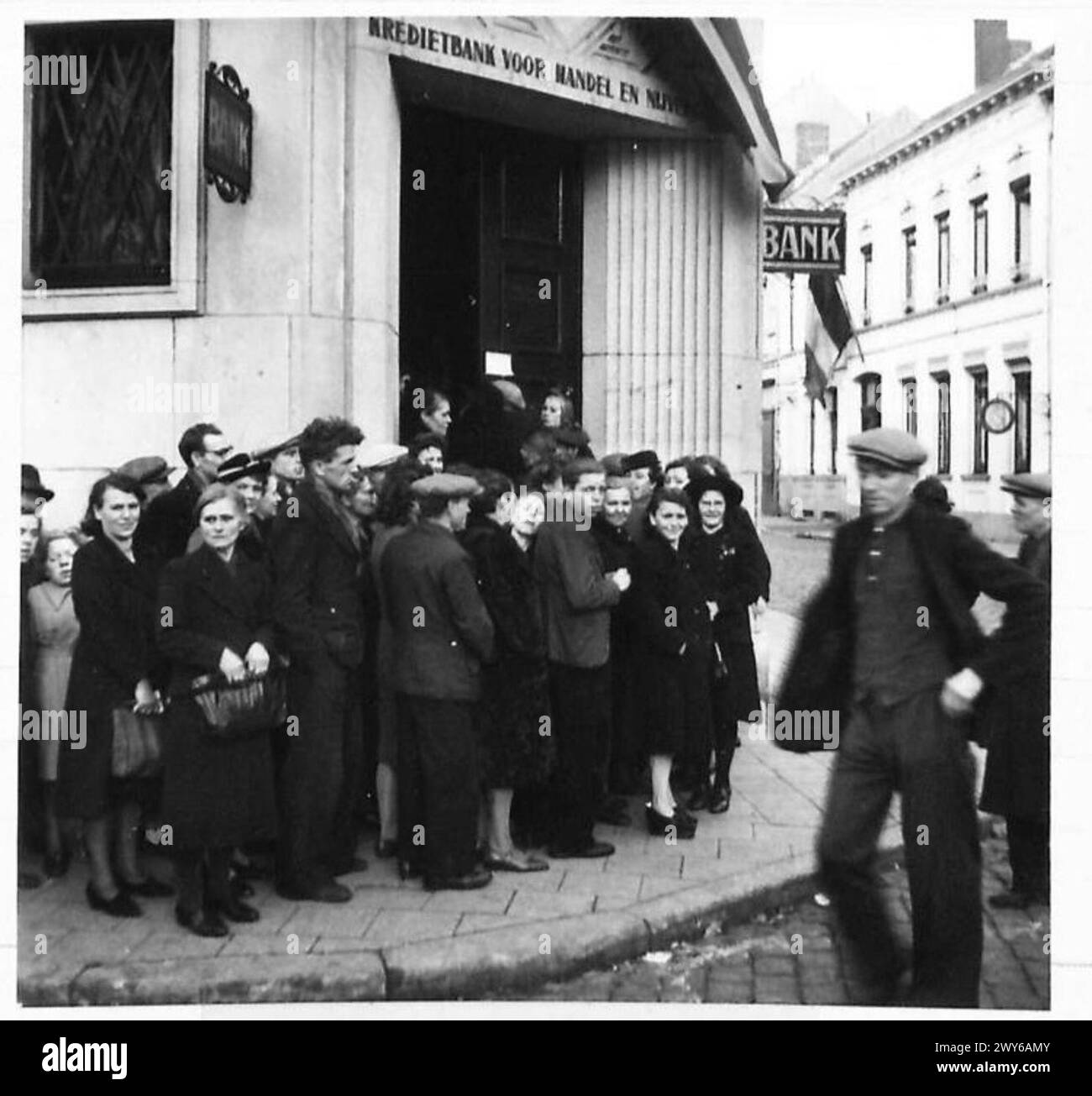 LIFE IN LIBERATED BELGIUM - To avoid inflation: The Germans flooded Belgium, as they did in other countries, with money.. To avoid a financial catastrophe, all the money circulated by the Germans is being withdrawn by the Belgian Government to enable them to assess the amount of supurious coinage. Here are civilians queuing outside a bank to receive new issue notes in exchange for the old. , British Army, 21st Army Group Stock Photo