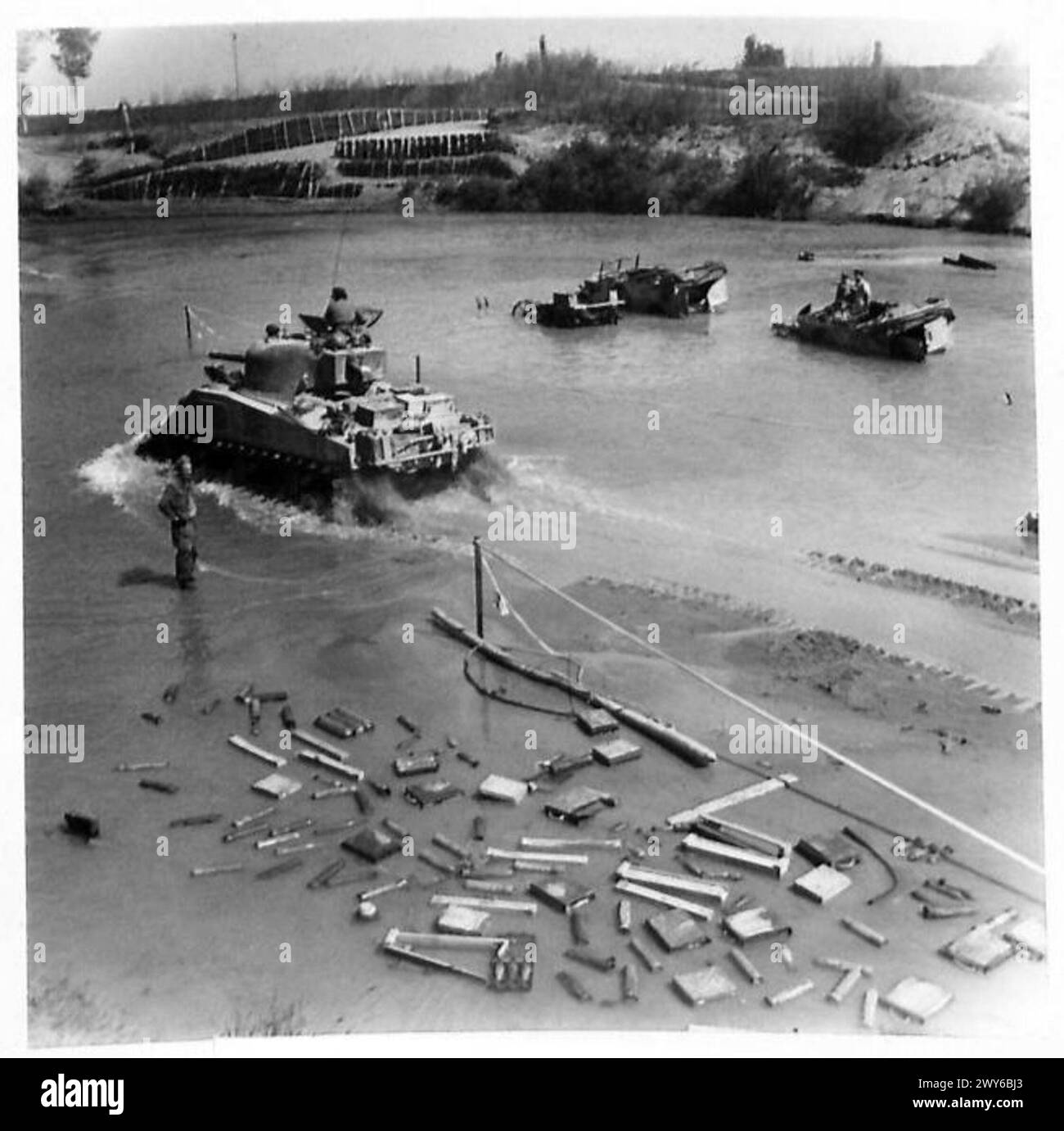 EIGHTH ARMY ADVANCE - A Sherman tank ford the River Reno. Enemy equipment and transport, caught by our Air Forces are seen in the river , Stock Photo