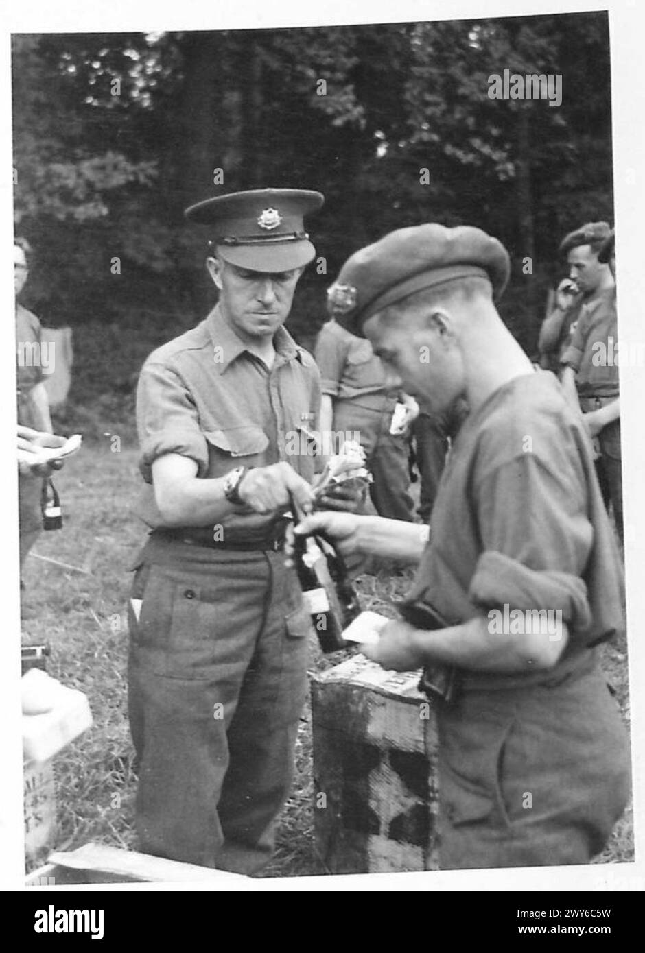 TROOPS RECEIVE BEER AMP NAAFI SUPPLIES IN NORMANDY - One of the troops of Defence Company, 2 Army Headquarters, TAC, is seen purchasing a bottle of beer from the CSM. , British Army, 21st Army Group Stock Photo