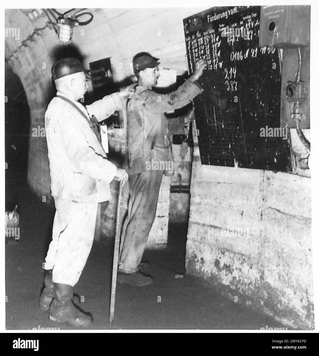 THE NORTH GERMAN COAL CONTROL - An underground foreman checks the number of train loads being chalked up by one of his workers. , British Army of the Rhine Stock Photo