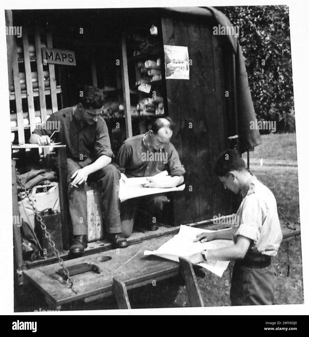 A CORPS HQ. IN FRANCE An officer collects his maps from Corps map