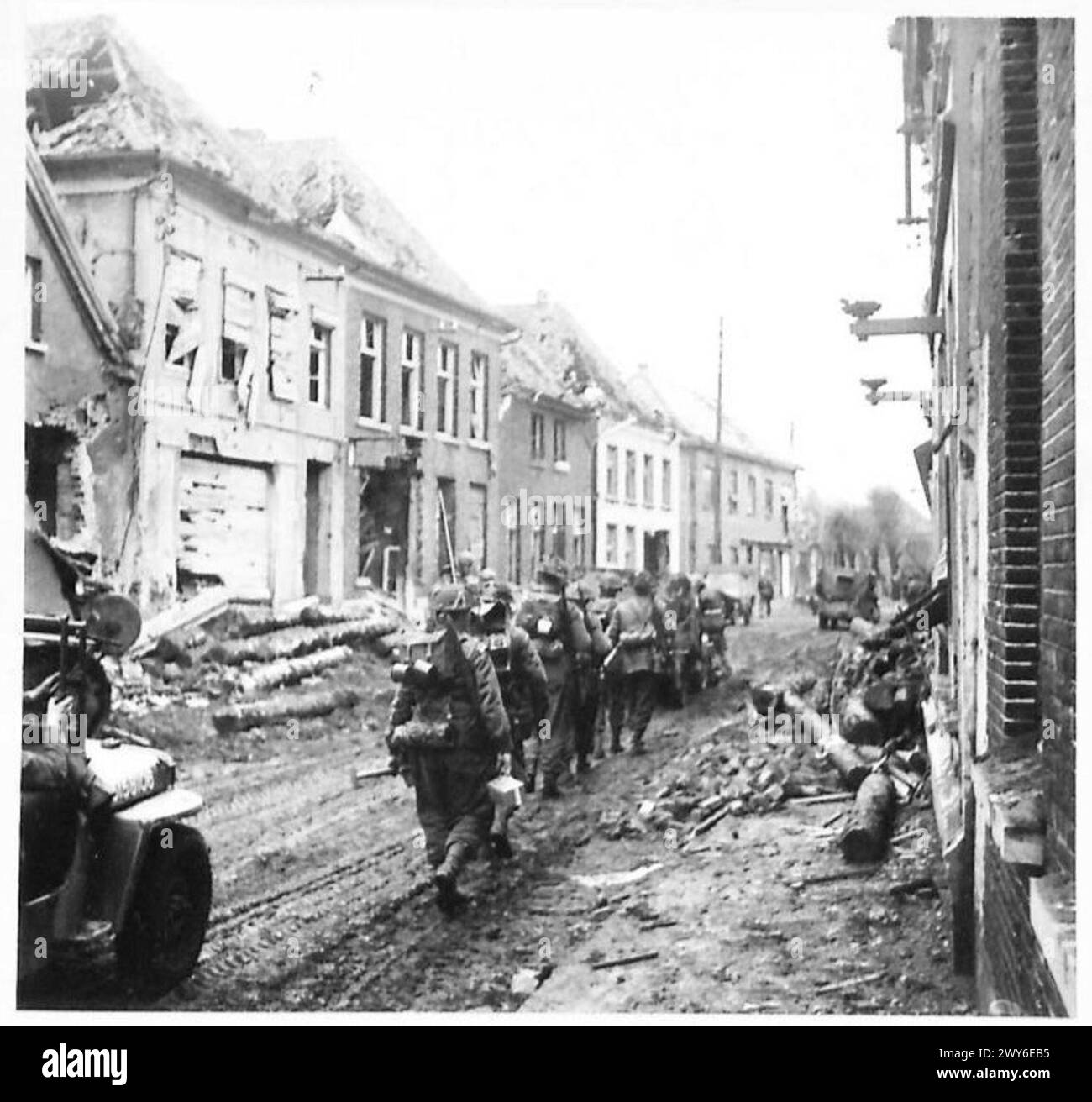 British and Canadian infantry advance through the damaged town of ...