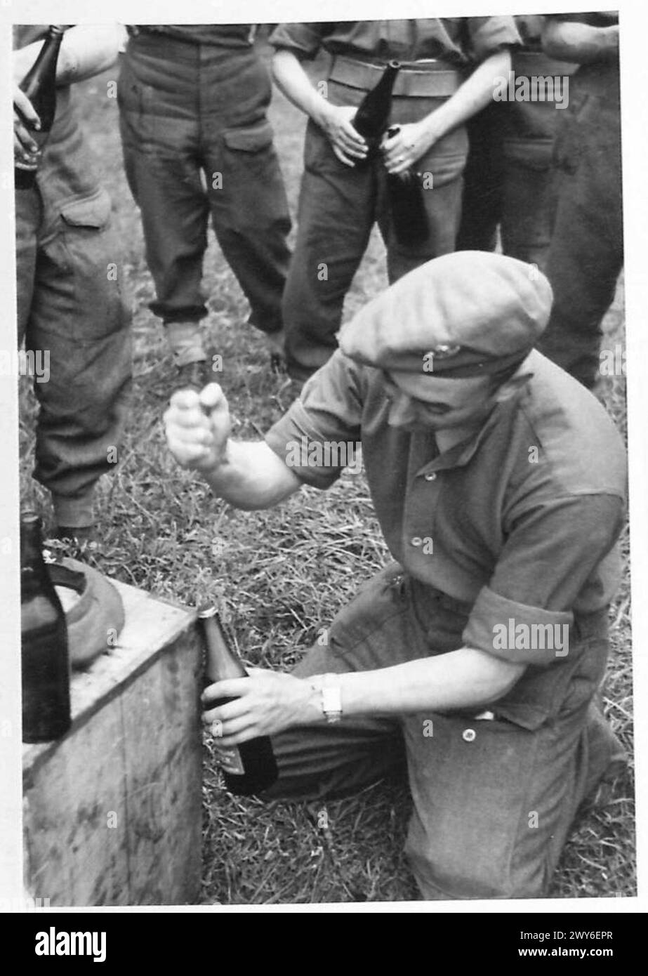 TROOPS RECEIVE BEER AMP NAAFI SUPPLIES IN NORMANDY - Private A. Jacobs, 8 Durham Light Infantry, of 8 King Edward's Terrace, St. Mark Street, Birmingham 1, obliges some of the lads by opening their bottles. , British Army, 21st Army Group Stock Photo