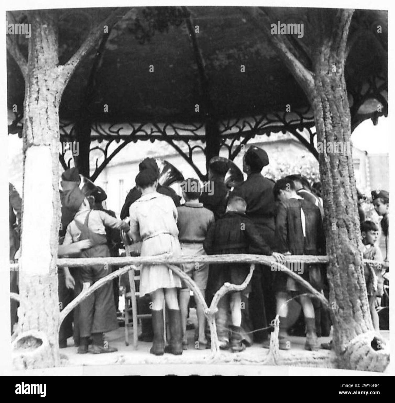 Children climb onto the bandstand to watch the Canadian Army band ...