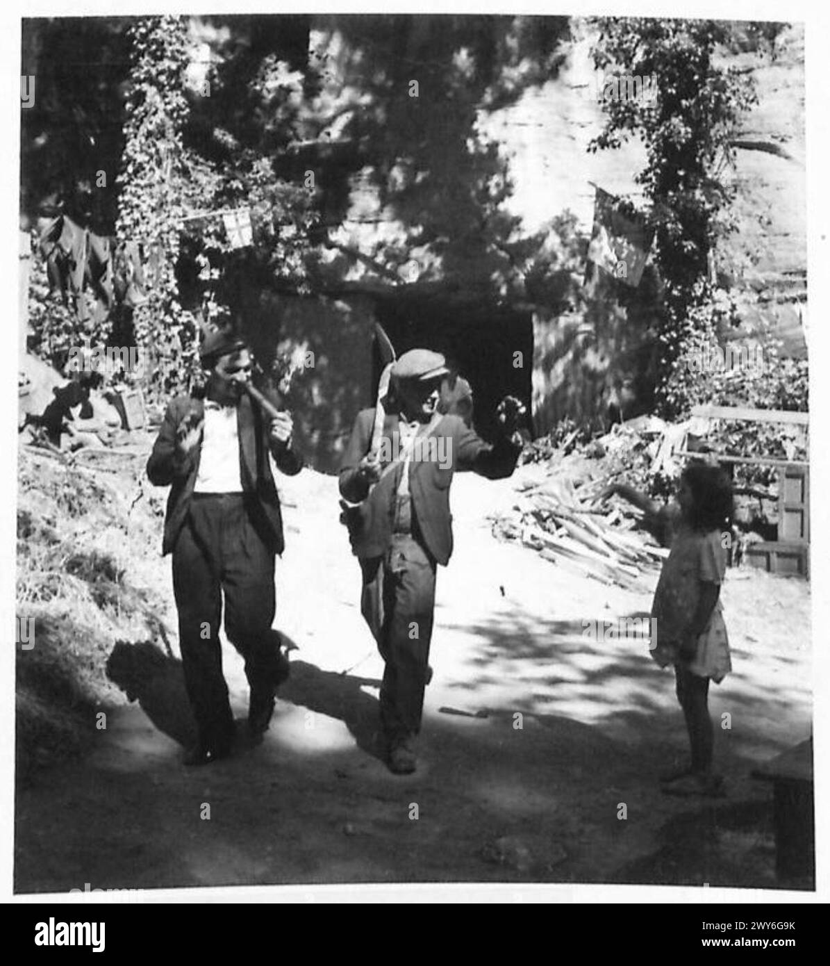 BOMBED OUT FAMILIES FROM CAEN LIVE IN CAVES - The father and son-in-law