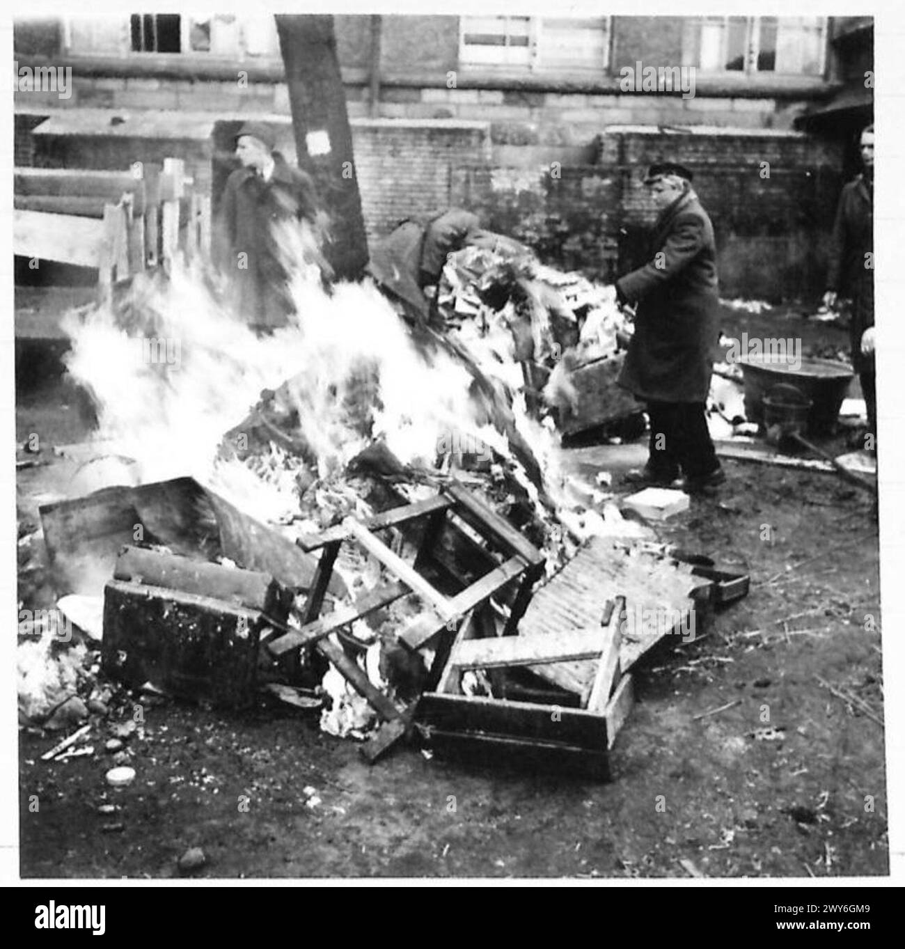 MILITARY GOVERNMENT IN RHEINE - Burning clothing and verminous straw which was used as bedding by forced labour in the Todt Organisation Building in Rheine. , British Army, 21st Army Group Stock Photo