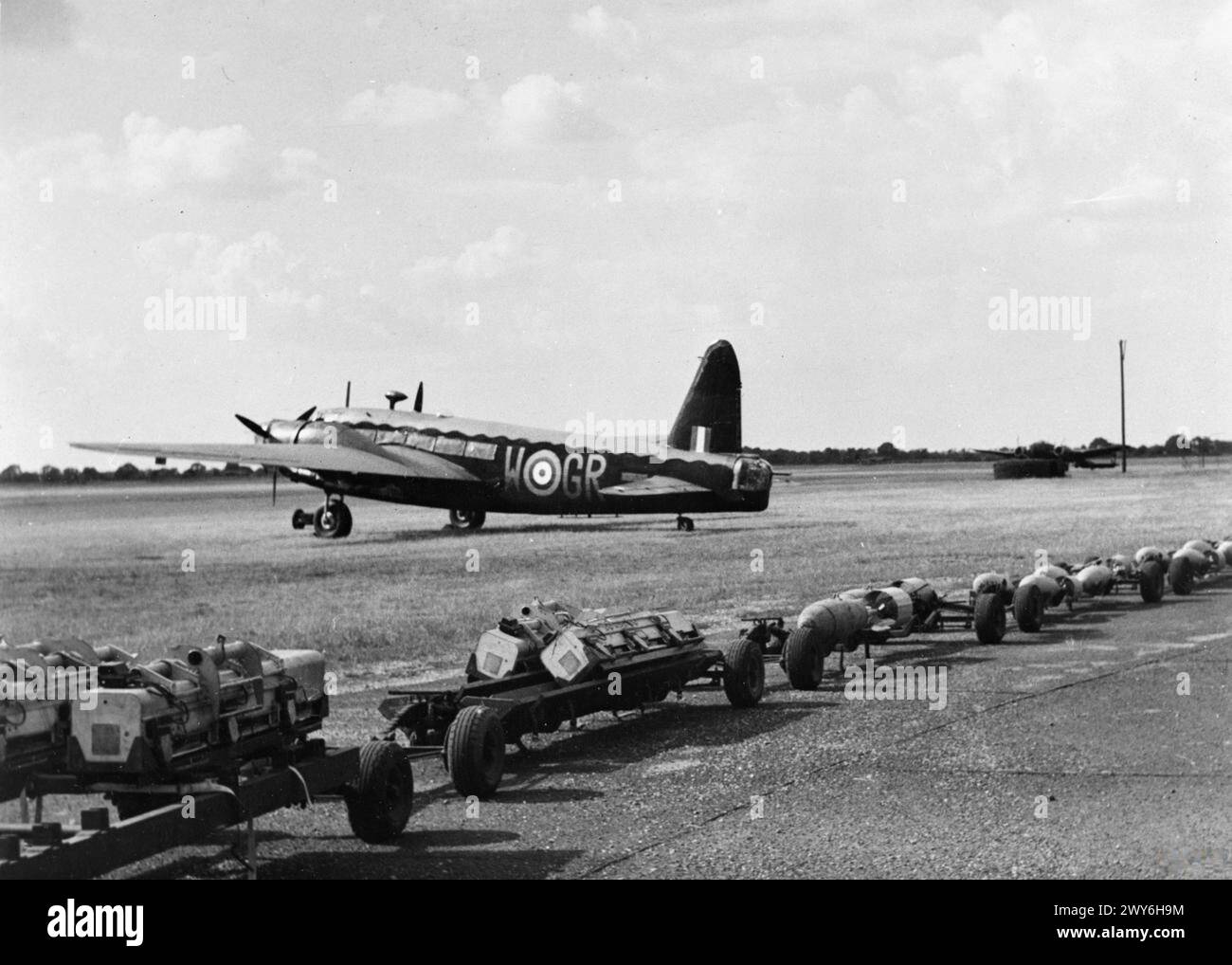 THE POLISH AIR FORCE IN BRITAIN, 1940-1947 - W5690 saw further service with No. 103 Squadron RAF, and Nos. 20 and 15 Operational Training Units, until it crash-landed while circuiting Hampstead Norreys, Berkshire, on 16 November 1943. Vickers Wellington B Mark IC (W5690, GR-W) of No. 301 Polish Bomber Squadron awaits a mixed load of incendiaries and 500 pounds GP bombs on trolleys at RAF Hemswell before a night sortie over Germany, July 1941. , Polish Air Force, Polish Air Force, 301 'Land of Pomerania' Bomber Squadron Stock Photo