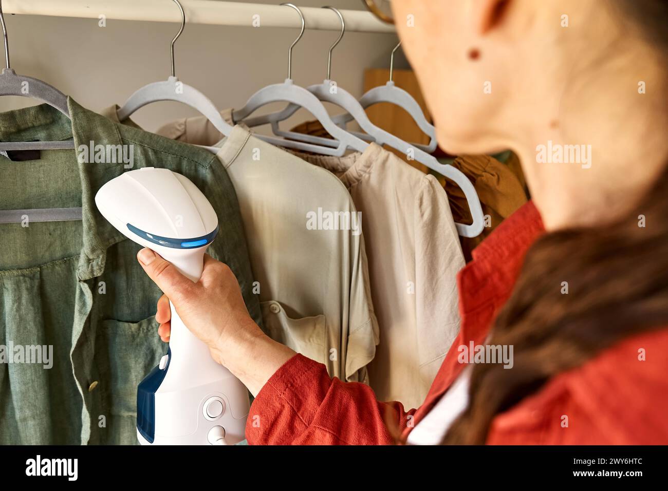 unrecognizable-woman-steaming-washed-clothes-at-home-housewife-daily