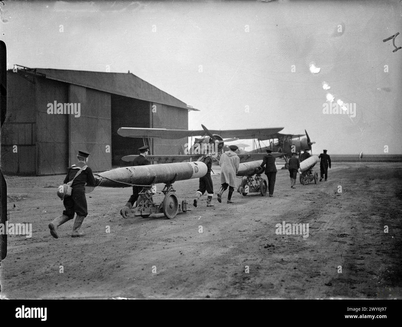 THE ROYAL NAVY DURING THE SECOND WORLD WAR - Wheeling out the torpedoes prior to their being fitted to the machines during training for pilots for naval aircraft at HMS JACKDAW, Royal Naval Air Station, Crail, Fife. , Royal Navy, HMS Jonquil, Sloop, (1915) Stock Photo