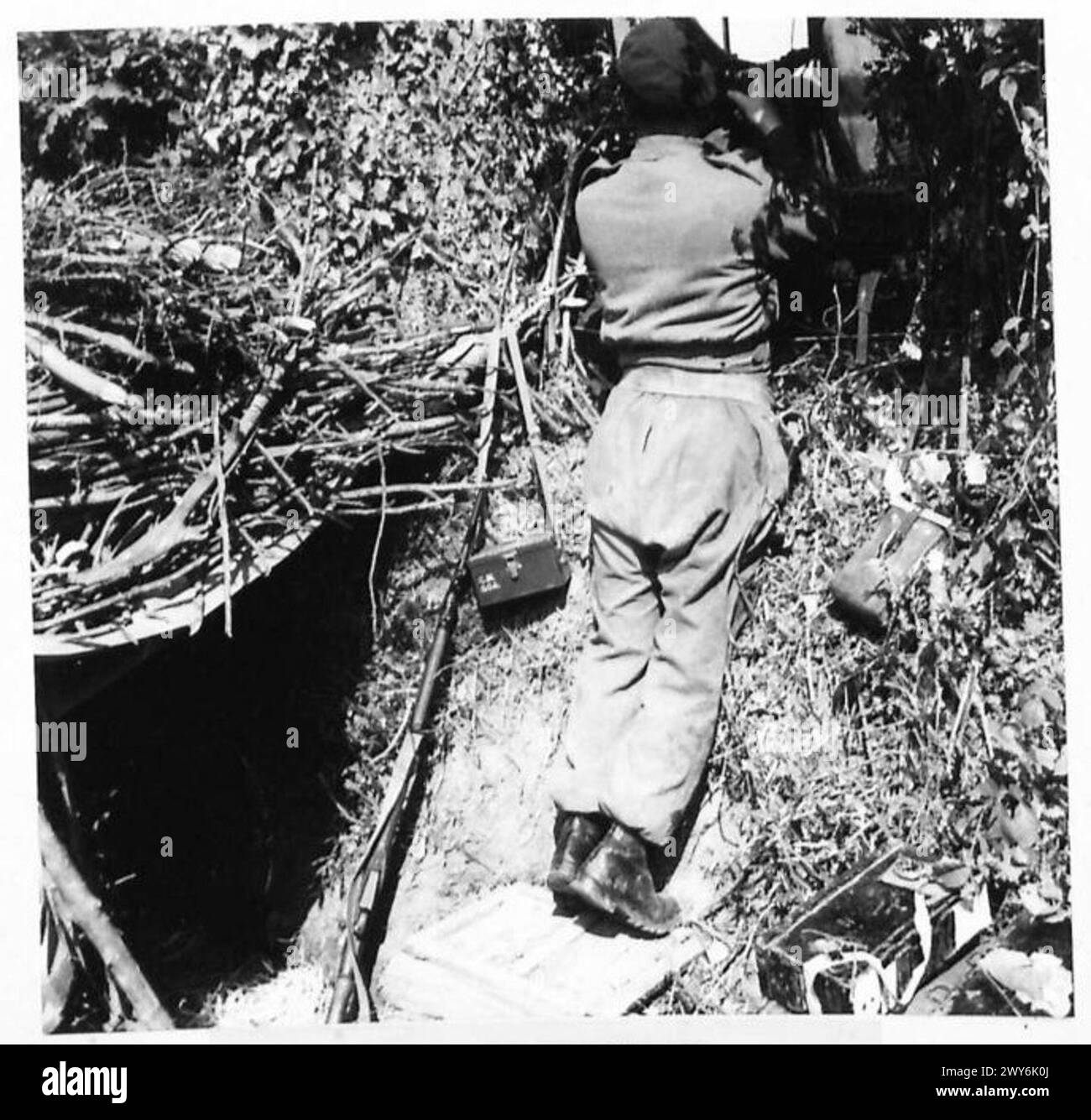 A commando machine gunner operates from a dugout outside Amfreville ...