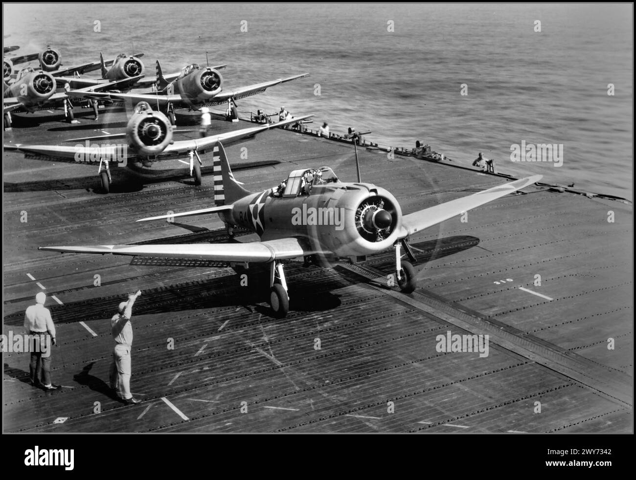 WW2 American dive bombers Douglas SBD-3 Dauntless from the 6th Bomb Squadron (Bombing Squadron 6, VB-6) are preparing to take off from the aircraft carrier USS Enterprise (CV-6) for raid on Wake Island. 1941  The second plane in the frame is the air group commander, Lieutenant Commander Howard Young. This is indicated by the designation GC (Group Commander) on the front of the engine casing. The Battle of Wake Island was a battle of the Pacific campaign of World War II, fought on Wake Island. Dates: 8 Dec 1941 – 23 Dec 1941 Stock Photo