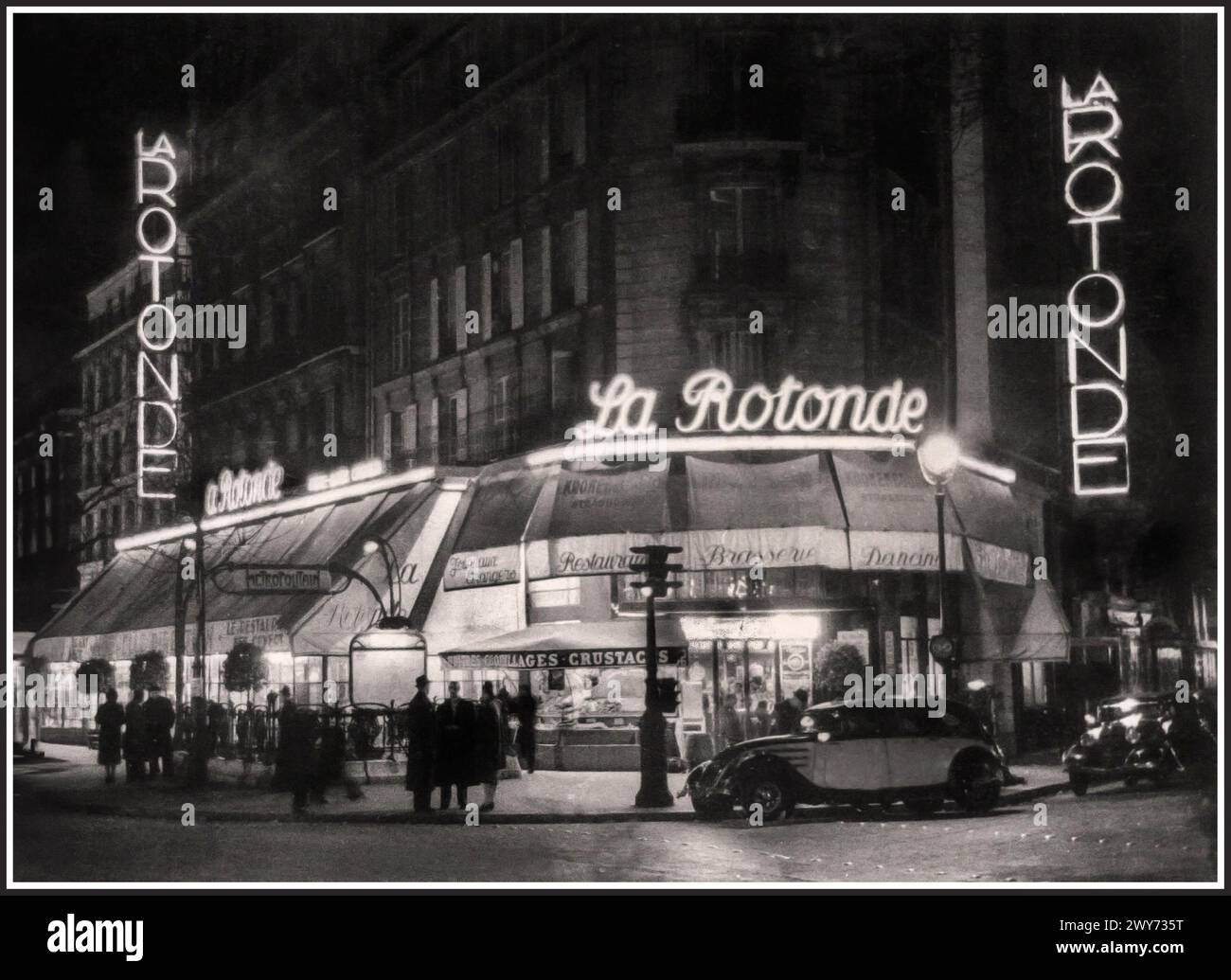 1920s Paris Vintage Retro Famous Cafe Restaurant 'LA ROTONDE' Brasserie Dancing Paris France. La Rotonde opened in 1911, situated directly across the Boulevard du Montparnasse from Le Dôme. During the 1920s, these cafes were at the center of expatriate life in Paris. Montparnasse was filled with cafes where artists could exchange ideas and and linger a table well into the night for a few centimes. Montparnasse Paris France Stock Photo