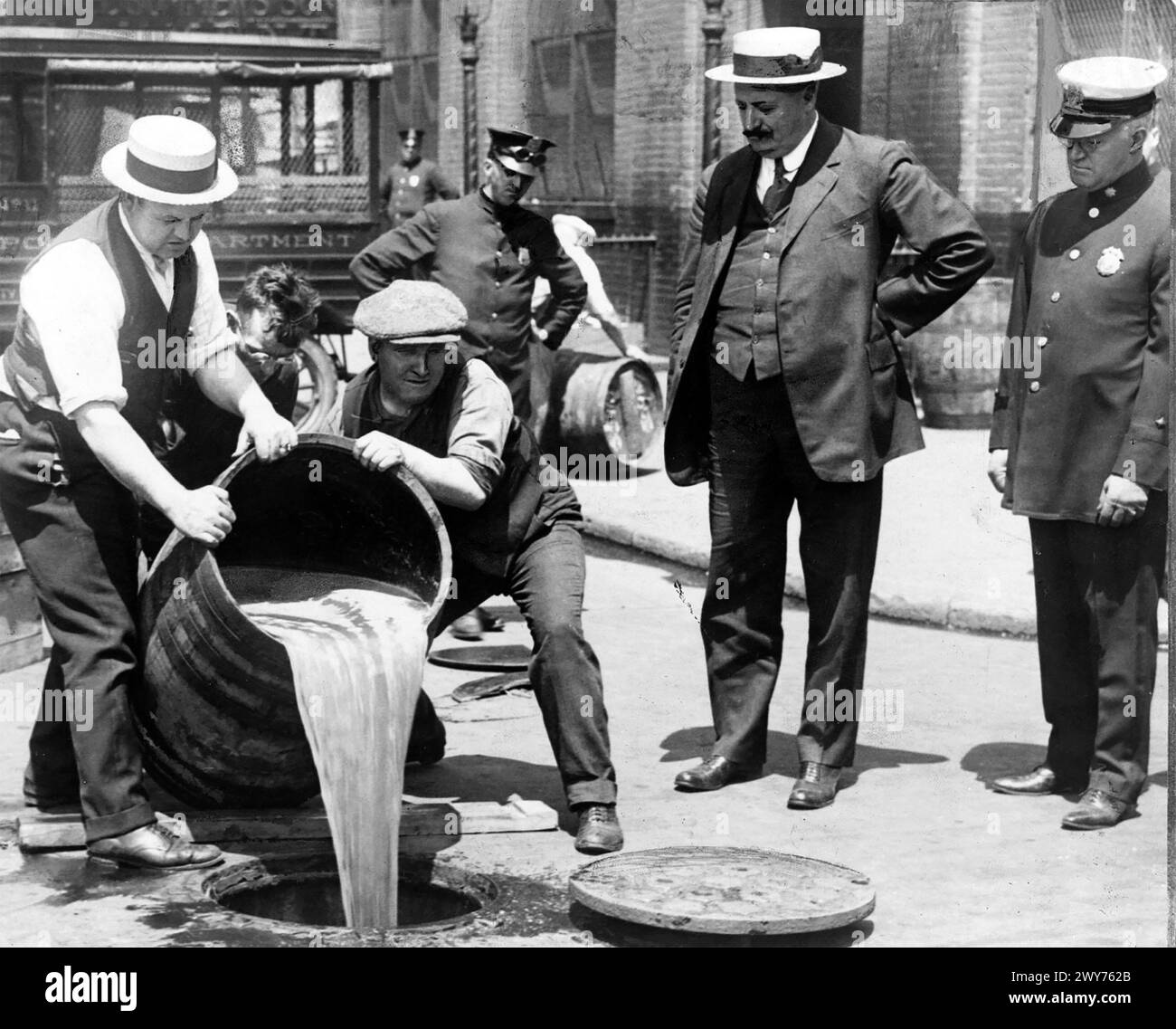 PROHIBITION IN THE USA. New York City Deputy Police Commissioner John  Leach watches  his agents pouring liquor into a drain following  a raid about 1925 Stock Photo