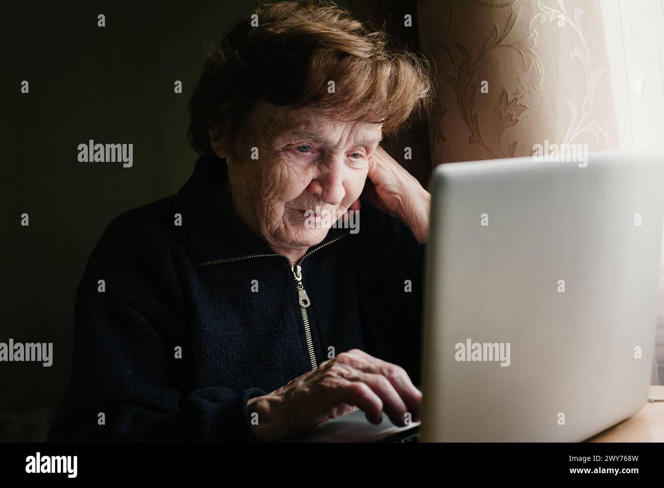 An old woman learning how to use a computer. Stock Photo