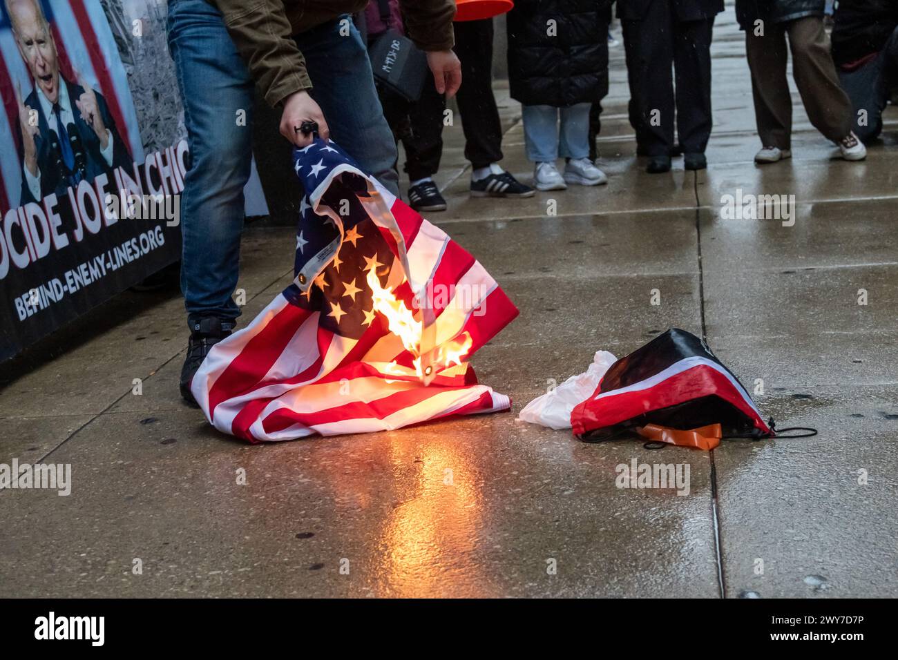 Marine corps veteran Zachary Kam burns a US flag at Chicago City Hall during a rally to 'Cancel the DNC'. Stock Photo
