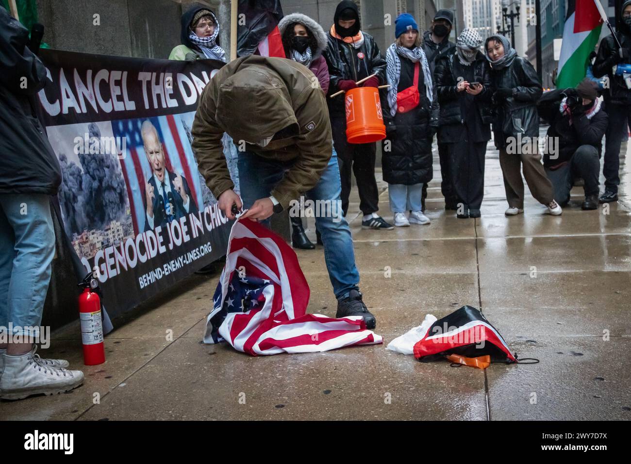 Marine corps veteran Zachary Kam burns a US flag at Chicago City Hall during a rally to 'Cancel the DNC'. Stock Photo