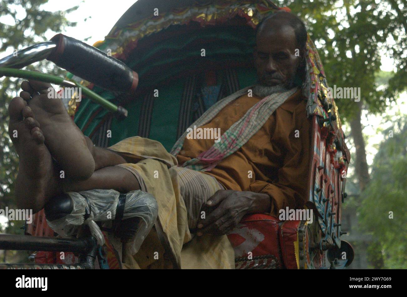 Hasan Reksha Dhaka, Bangladesh. 5th Apr, 2024. A rickshaw puller naps under the ...
