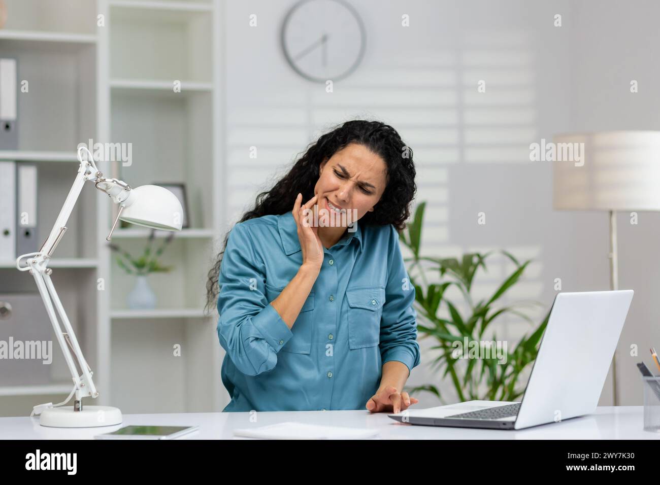 A professional woman experiences sudden toothache at her workplace ...