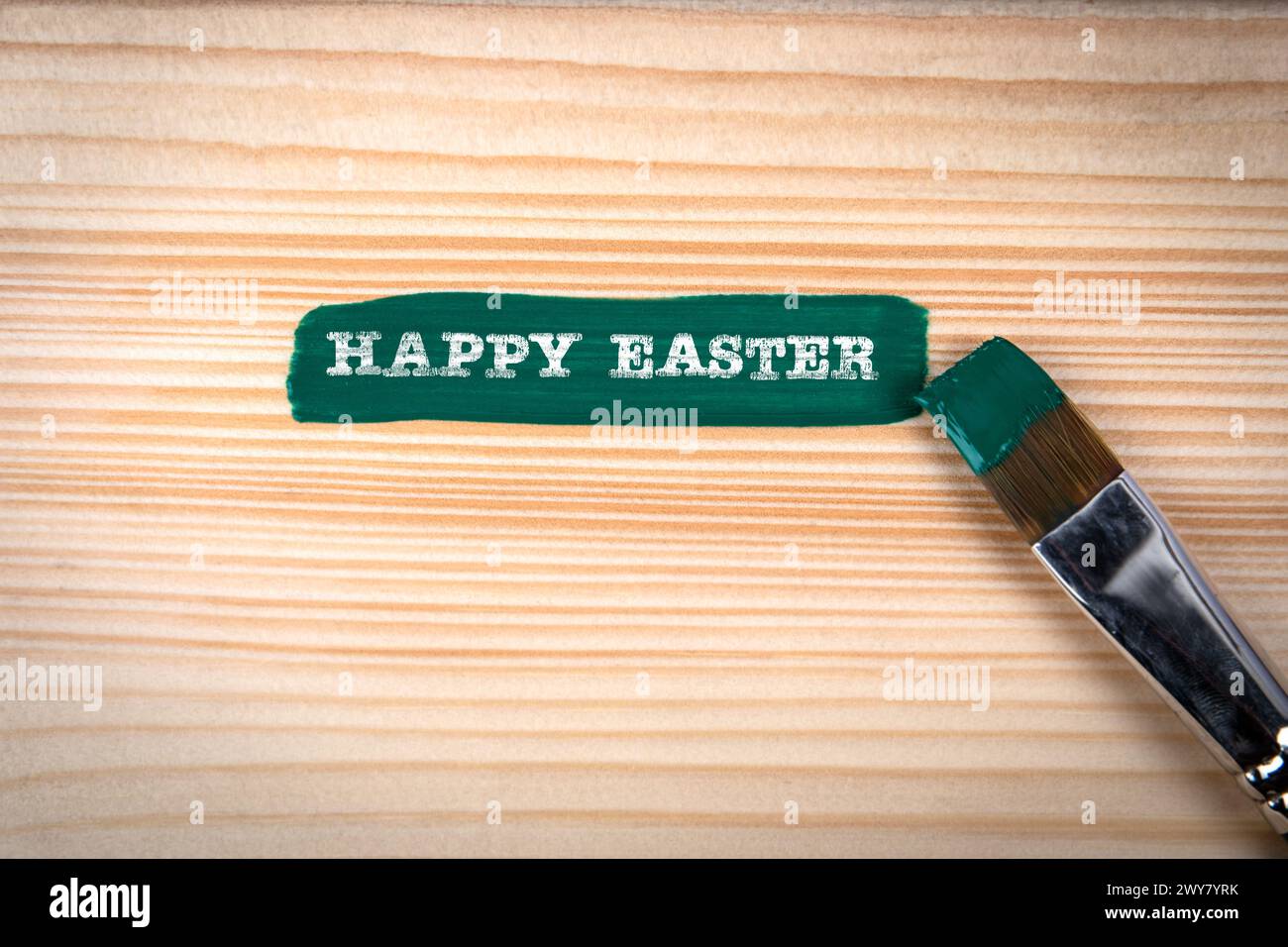 Happy Easter. Green paint and brush on wood texture background. Stock Photo
