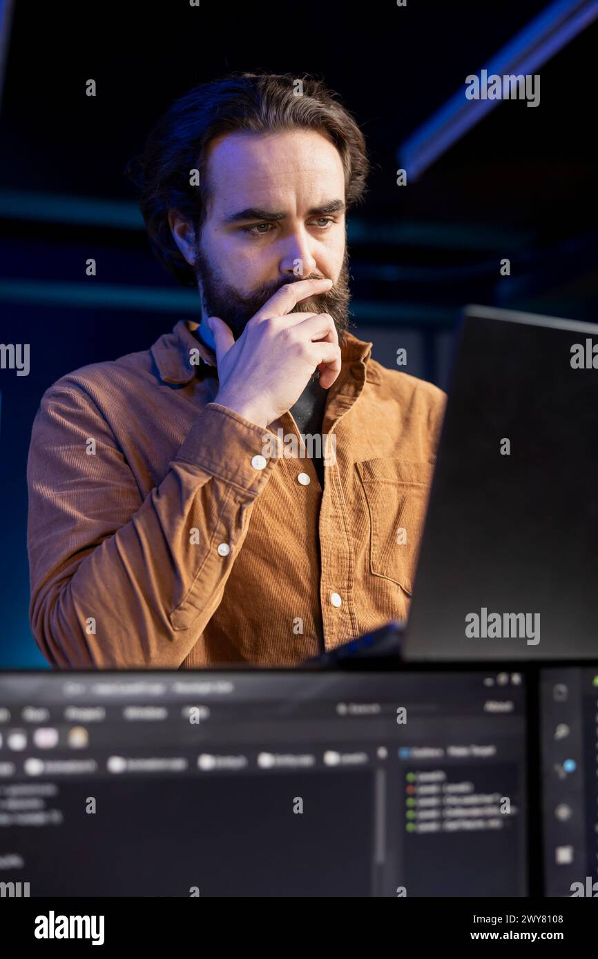 Reflective programmer debating how to design and develop software applications. Puzzled IT specialist trying to come up with solutions while implementing and maintaining company systems Stock Photo