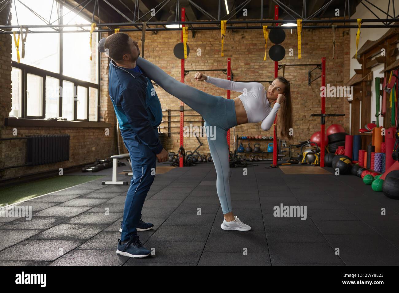 Young woman learning to fight with male trainer in fit gym Stock Photo ...