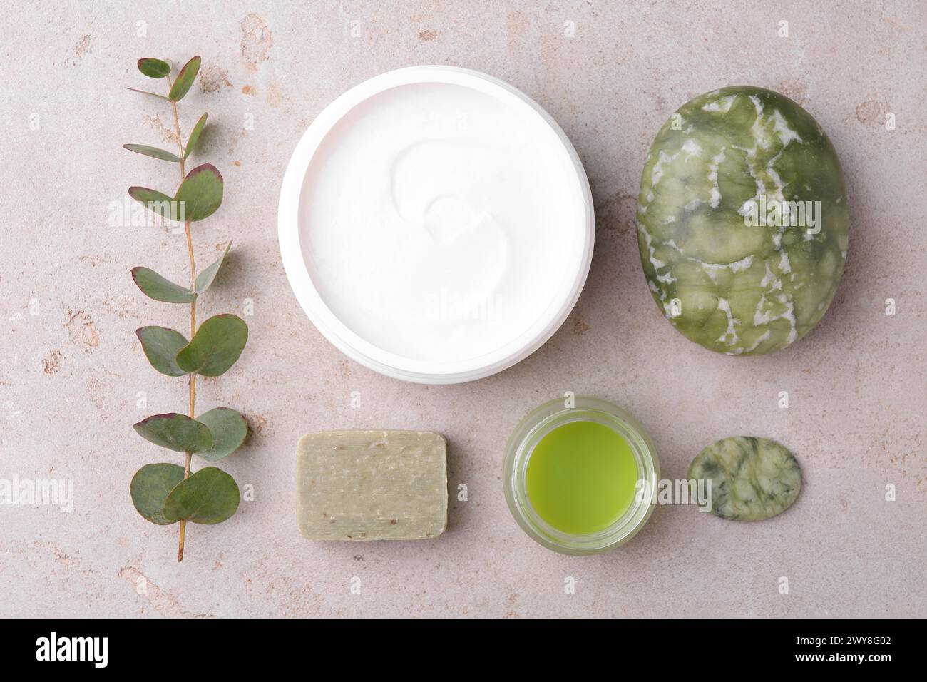 Flat lay composition with jars of cream on light textured table. Body ...