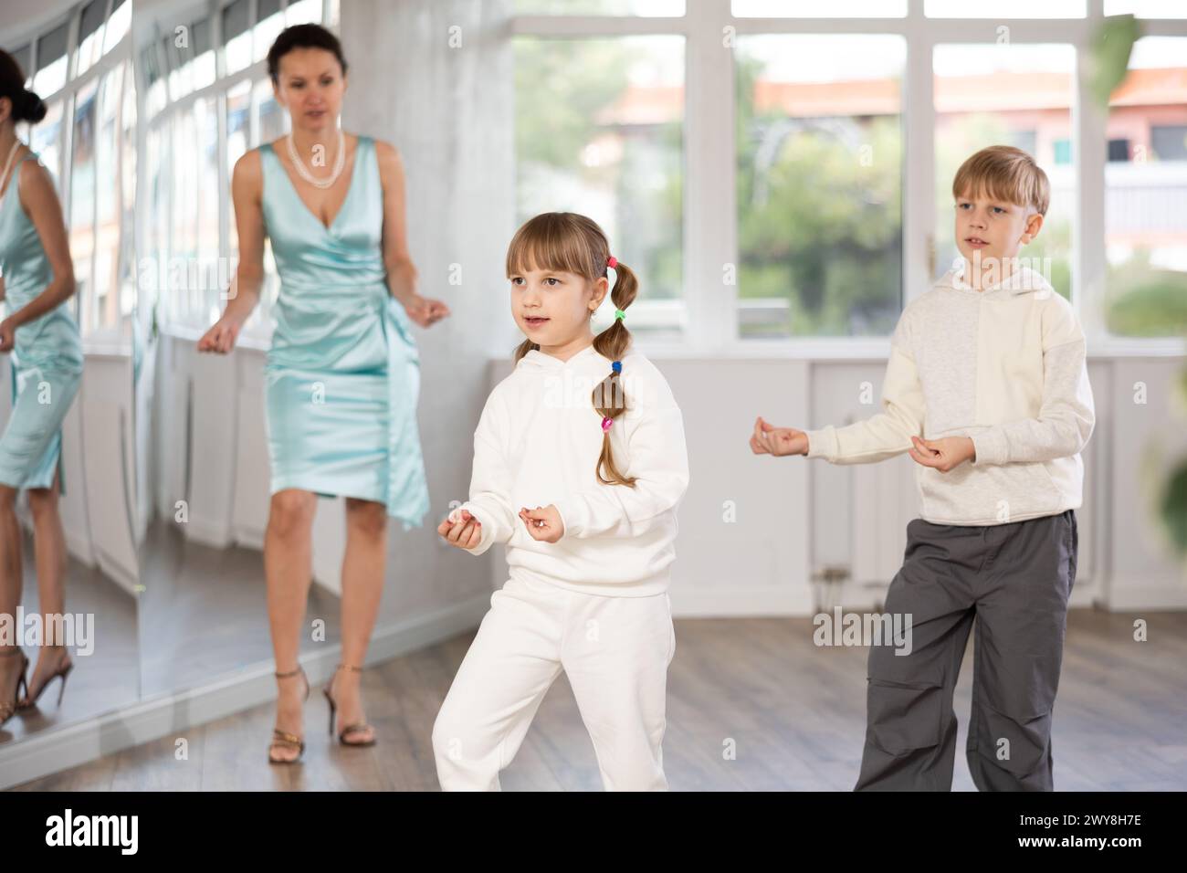 Tween girl and boy snapping fingers while rehearsing jazz style dance