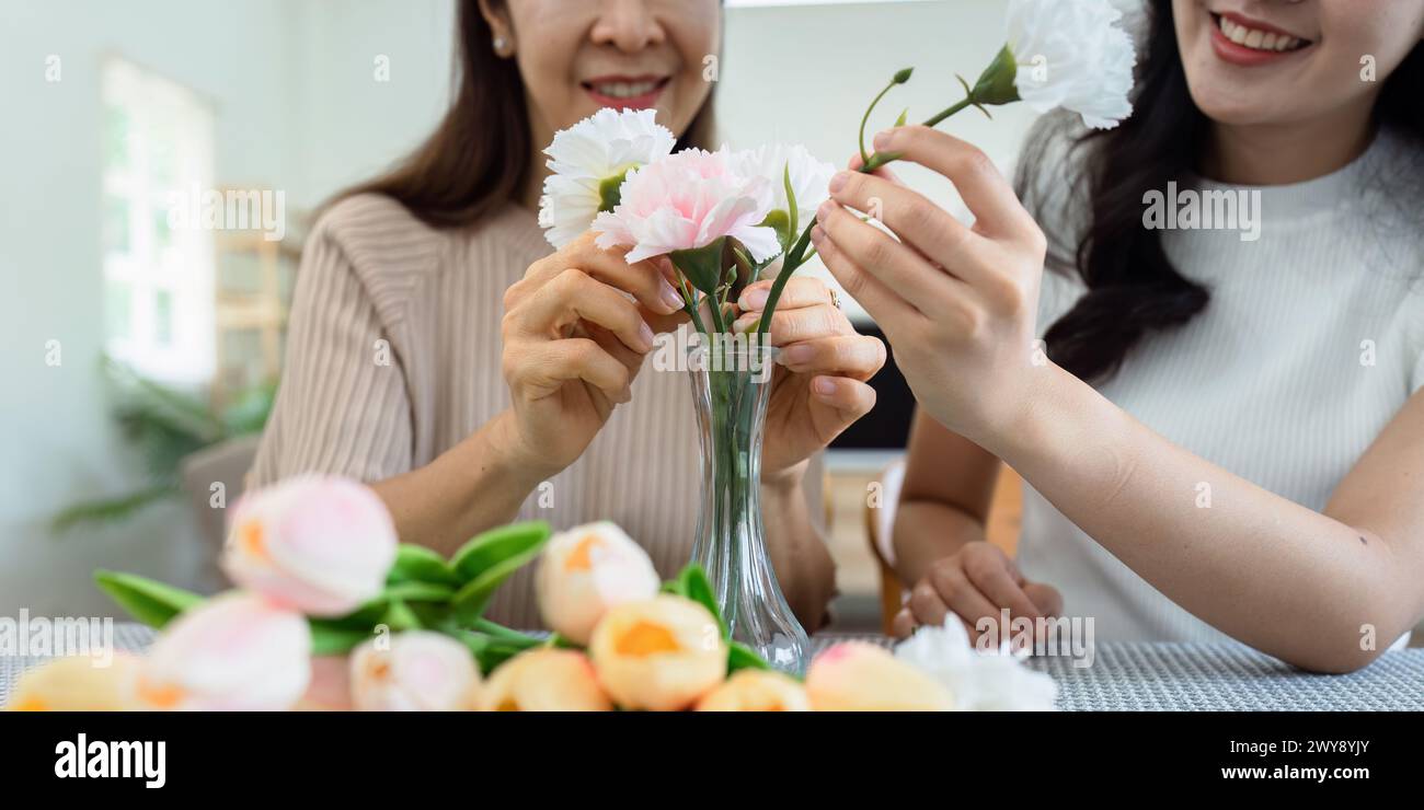 Mother and daughter arrange flower together at home on the weekend ...