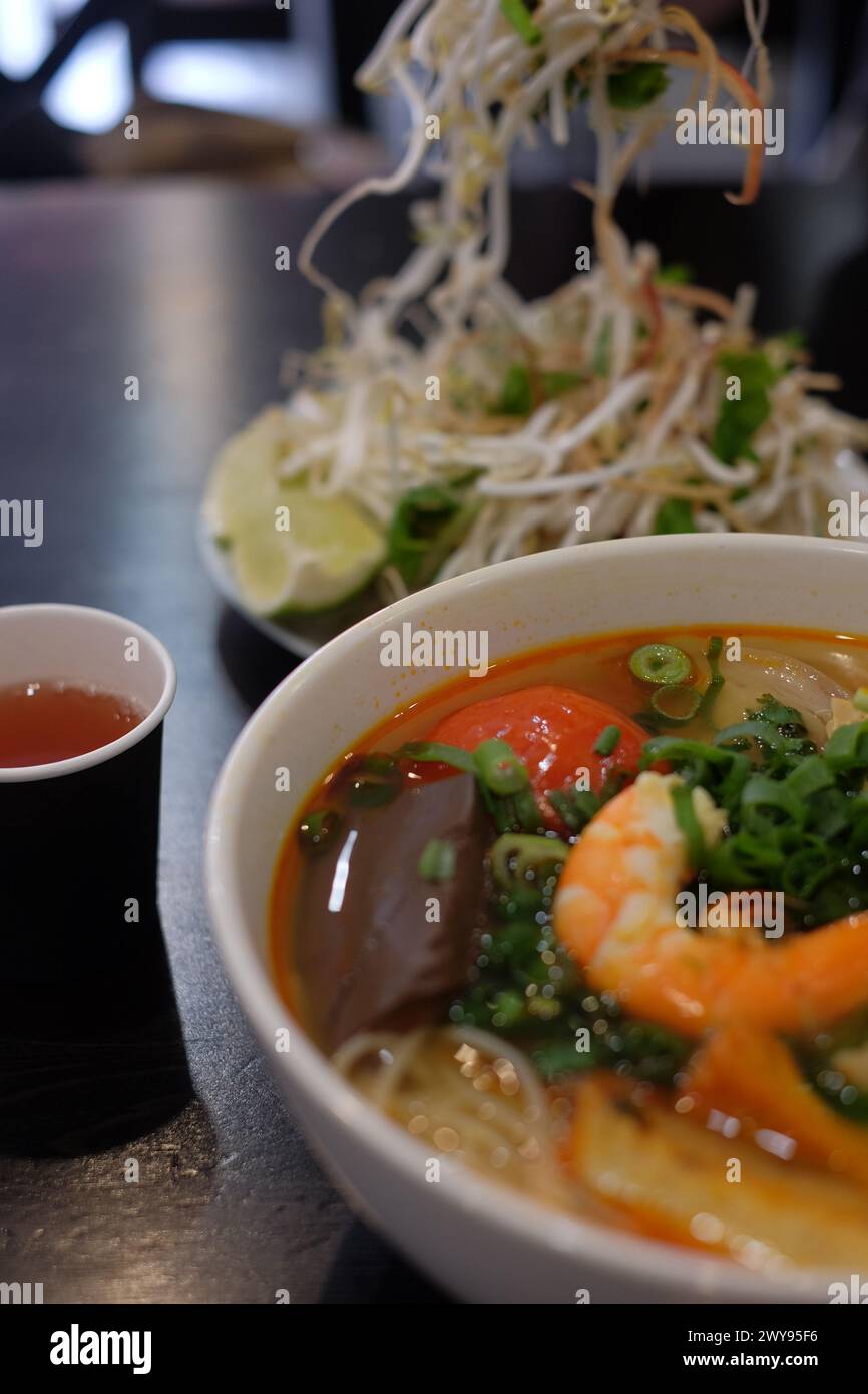 Detail of Bun Rieu Vietnamese Crab and Tomato Noodle Soup, tea and Bean Sprouts at Thanh Xuan restaurant in Canley Vale, Western Sydney Stock Photo